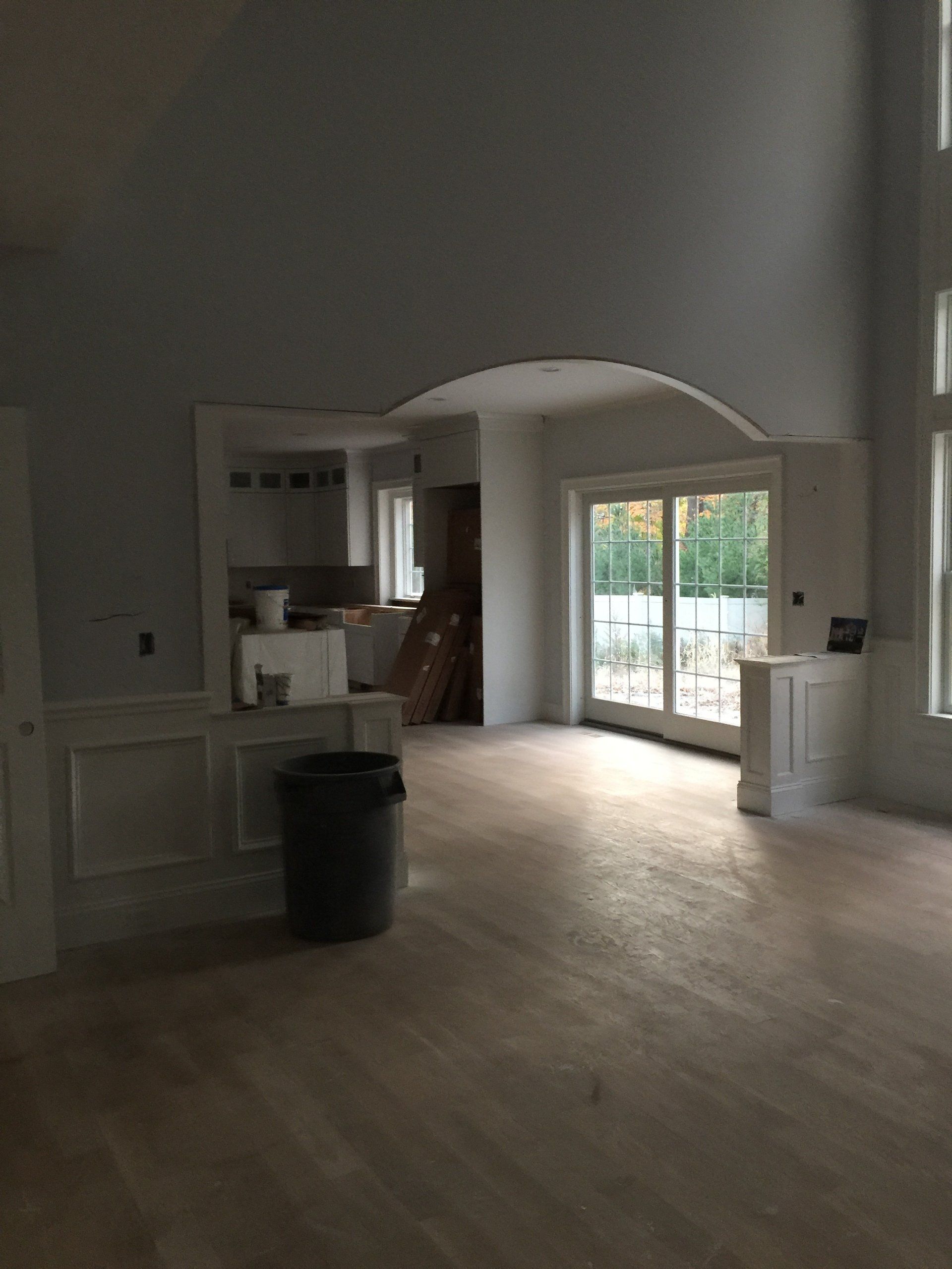 A large empty room with a trash can in the middle