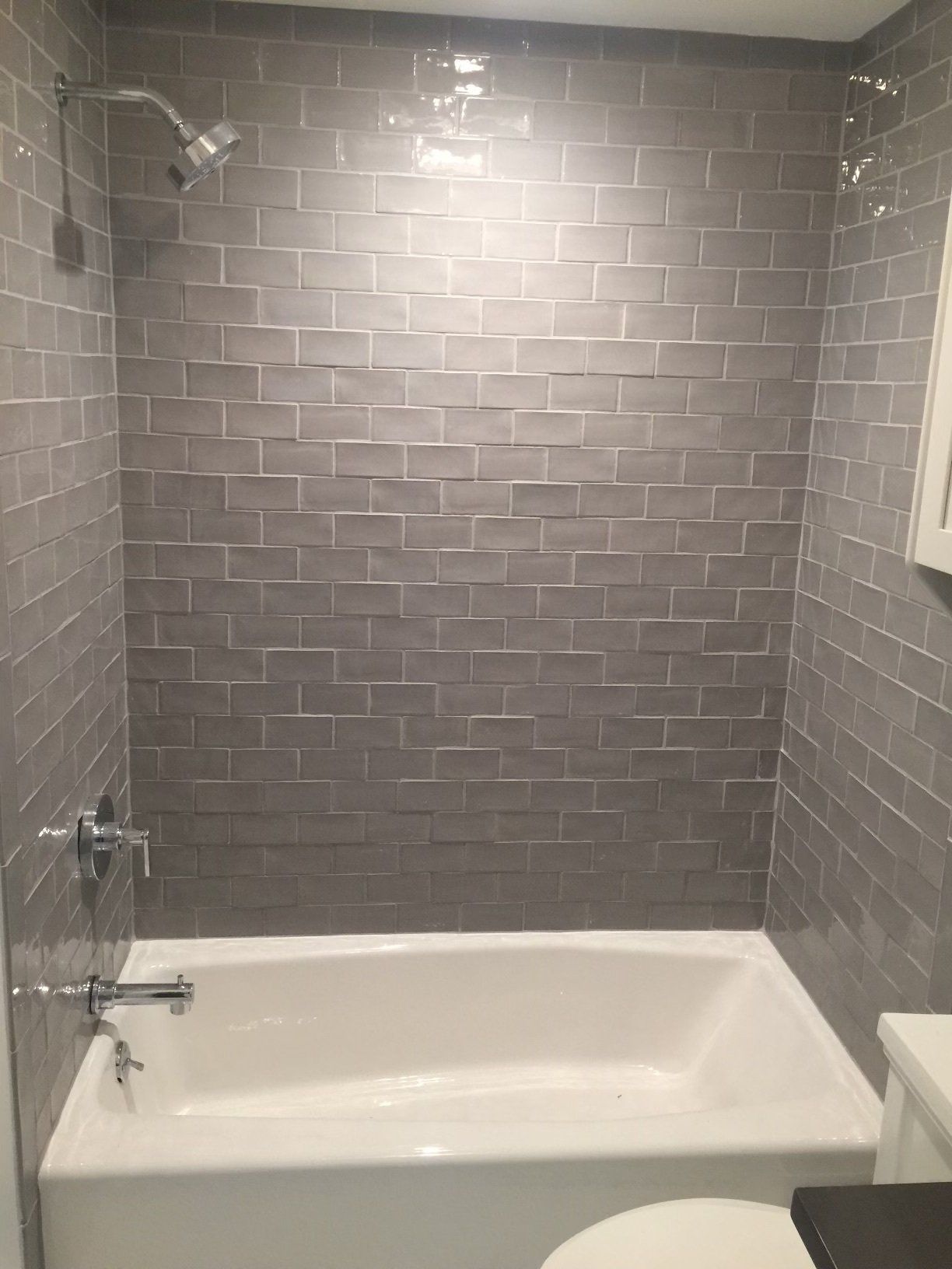 A bathroom with a bathtub , toilet and shower.