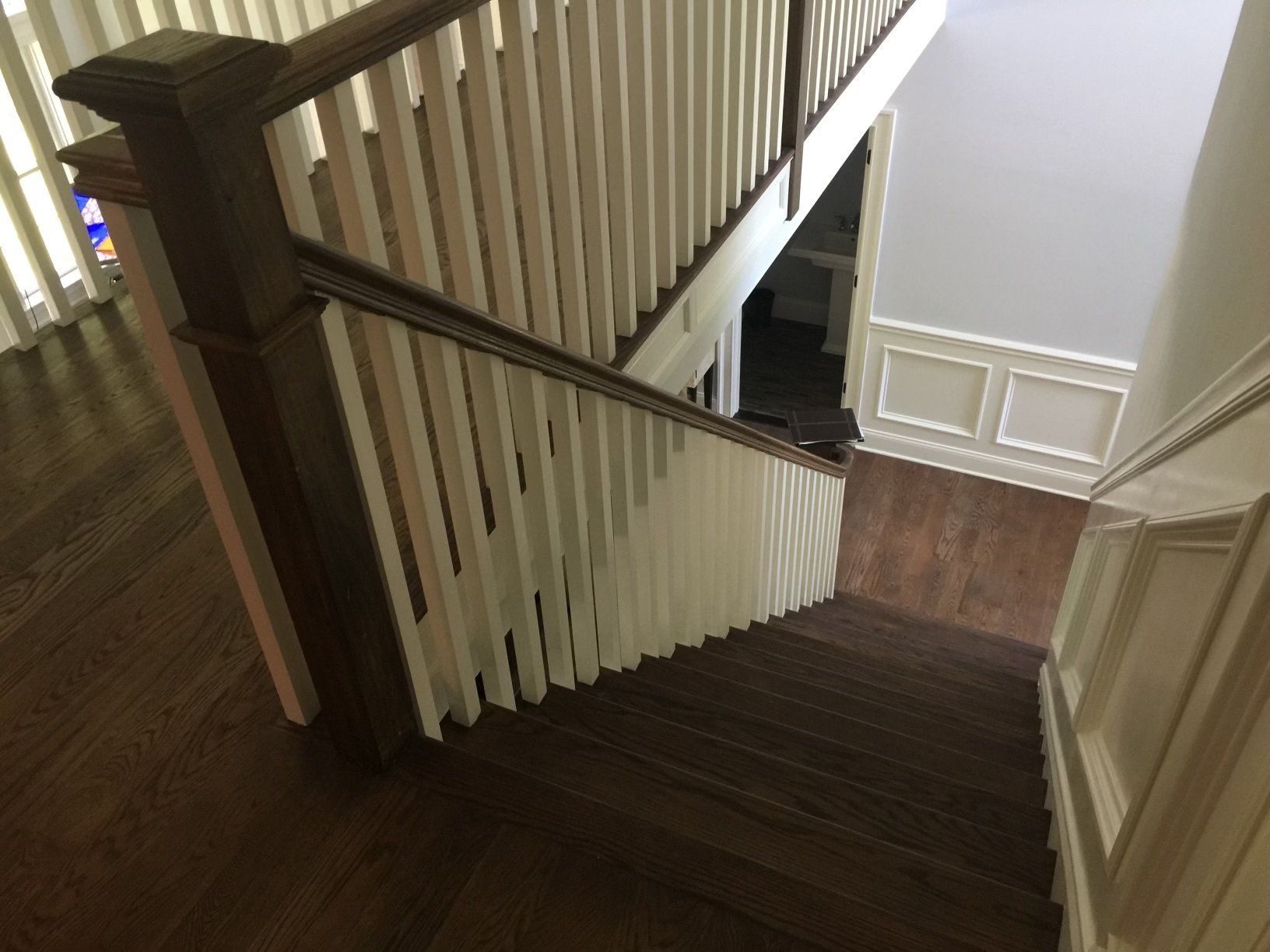 A staircase with a wooden railing and a white railing