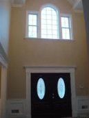 There is a large window above the door in the middle of the room.