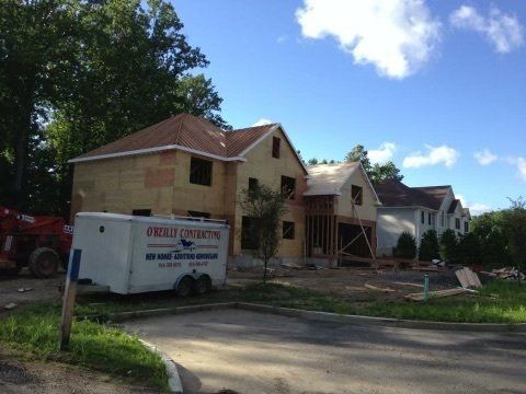 A j. kelly construction trailer is parked in front of a house under construction