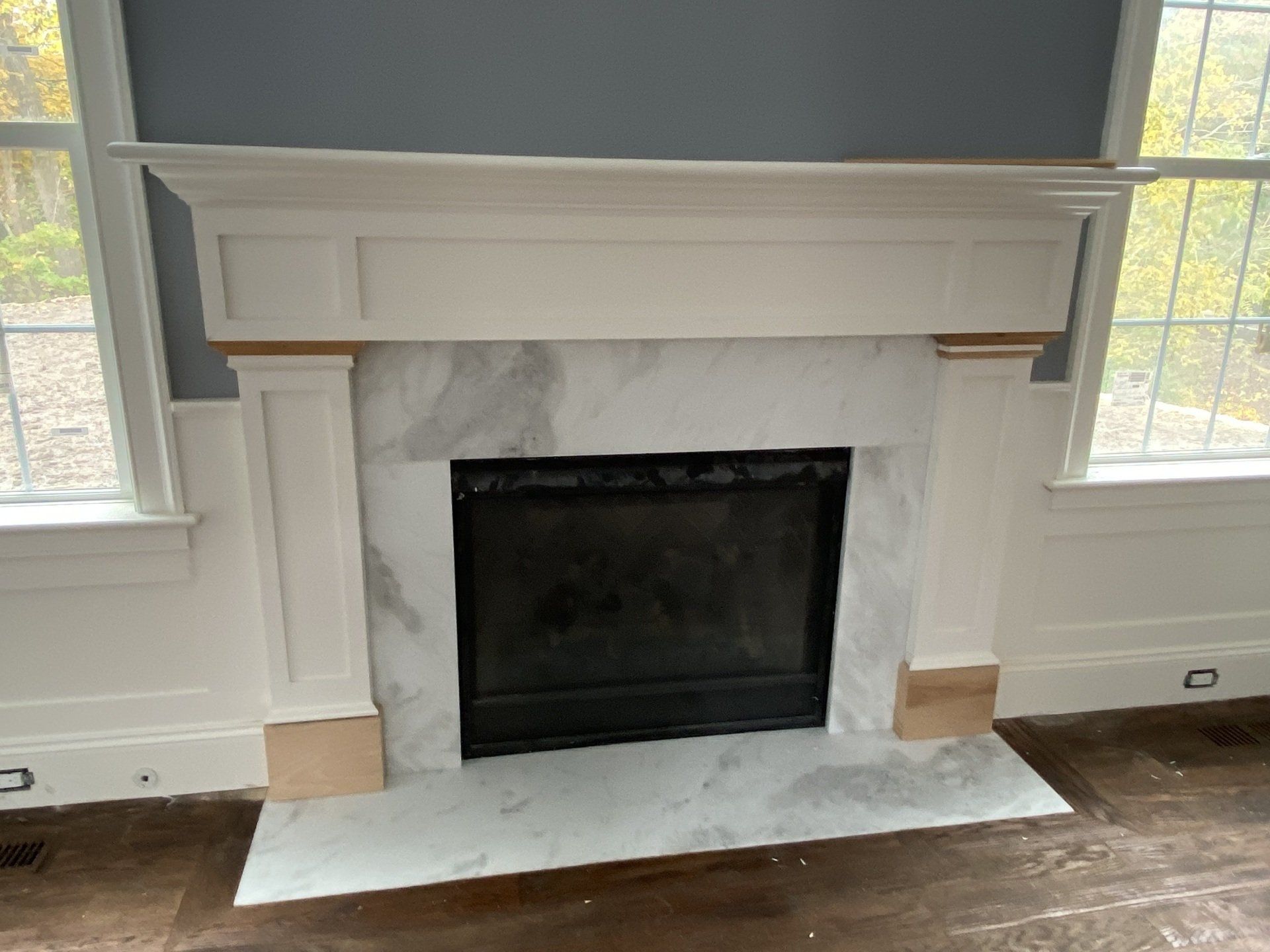 A fireplace with a marble mantle in a living room.