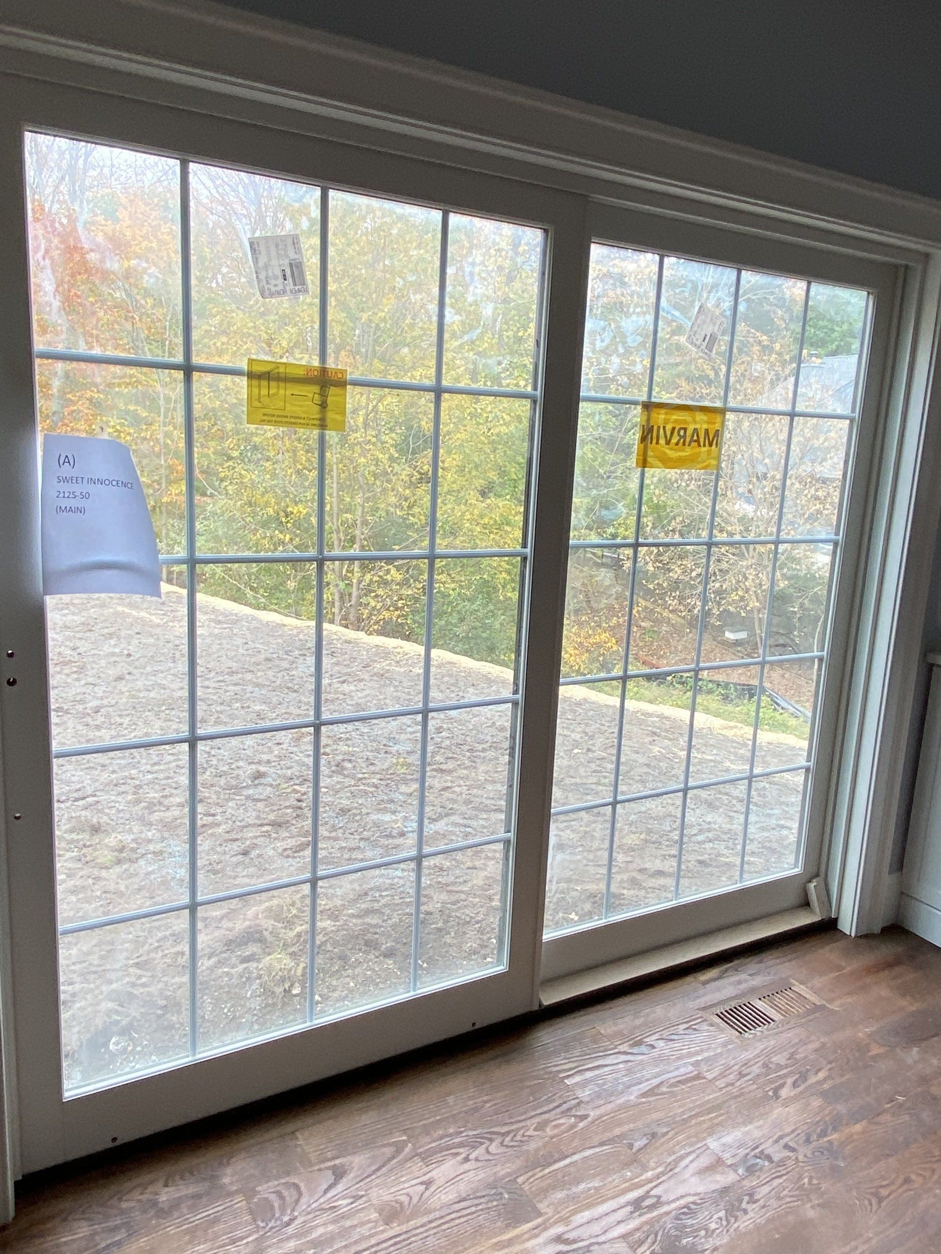 A room with a sliding glass door and a wooden floor.
