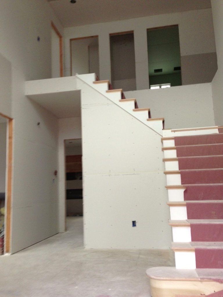 A staircase with a red carpet going up to the second floor