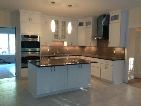 A kitchen with white cabinets and granite counter tops
