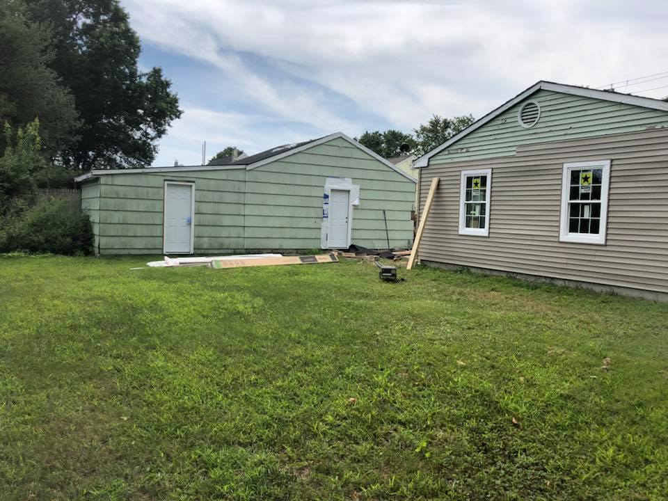 Two houses are sitting next to each other in a grassy yard.