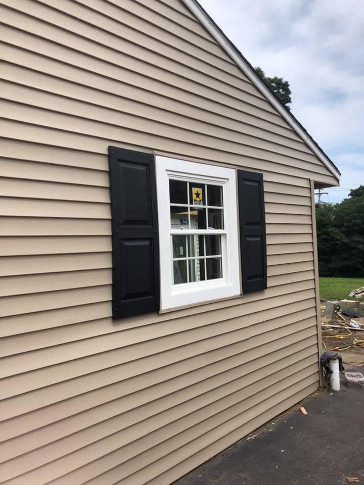 A house with a window and black shutters on it
