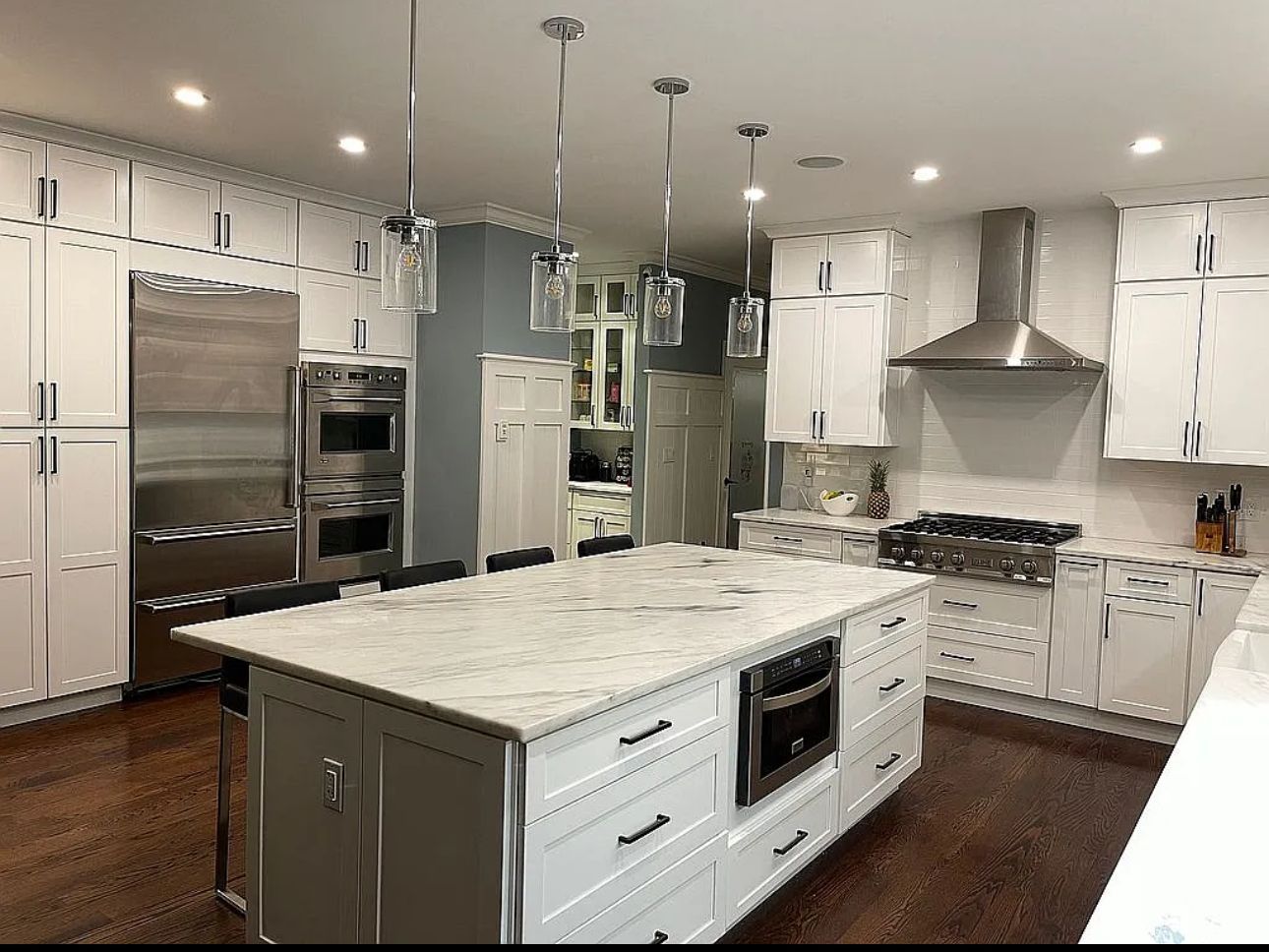 A kitchen with white cabinets and stainless steel appliances