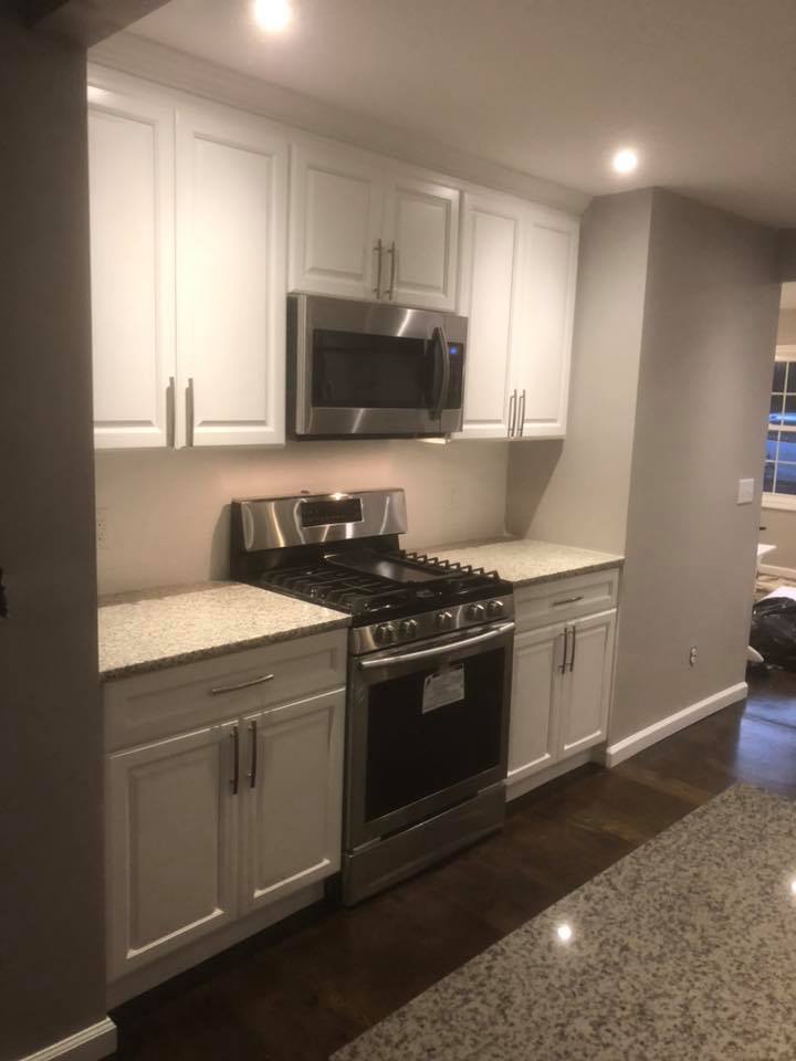 A kitchen with stainless steel appliances and white cabinets