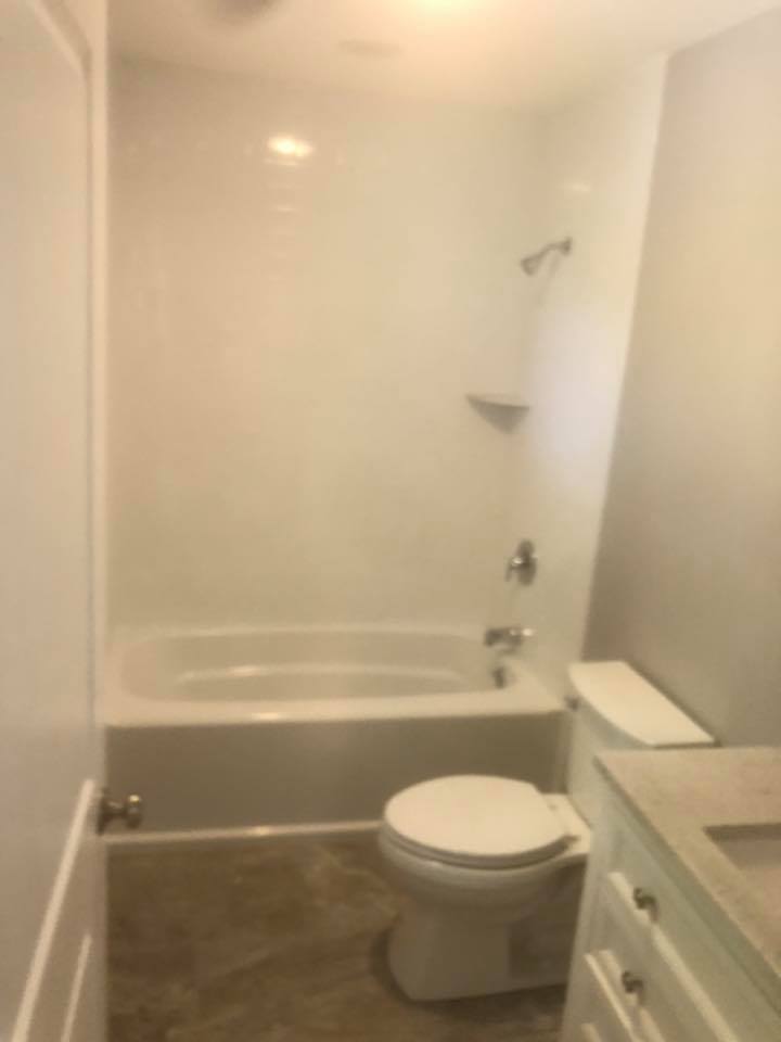 A bathroom with a toilet , bathtub and shower.