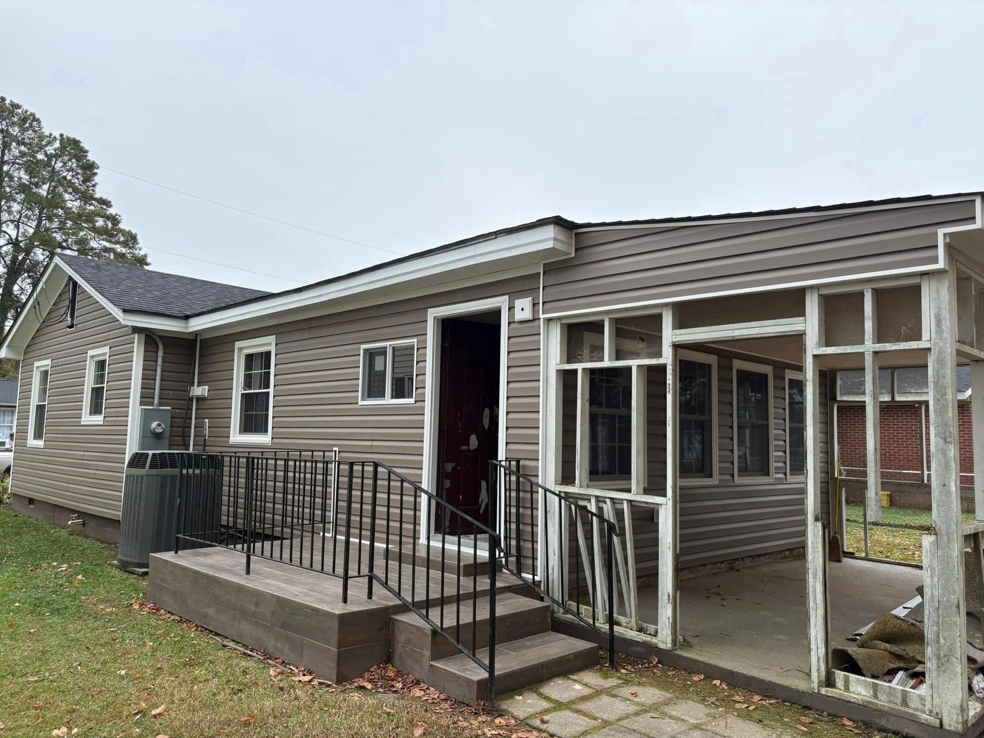 A small house with a screened in porch and stairs.