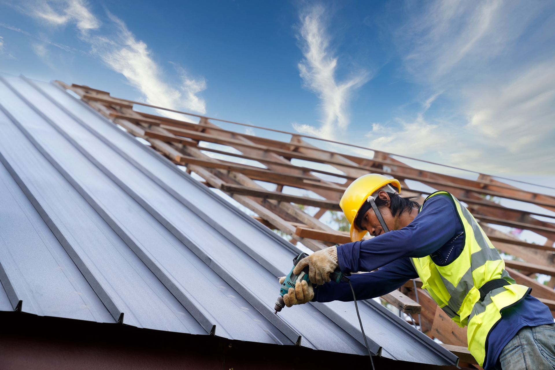 A construction worker is working on the roof of a building.