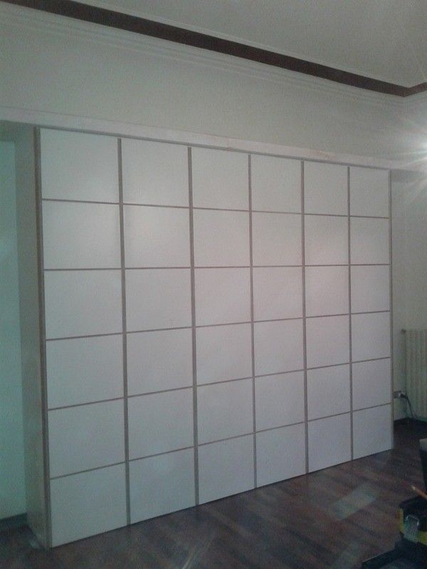 Mobile contenitore modulare bianco incassato nella parete, composto da più pannelli quadrati.