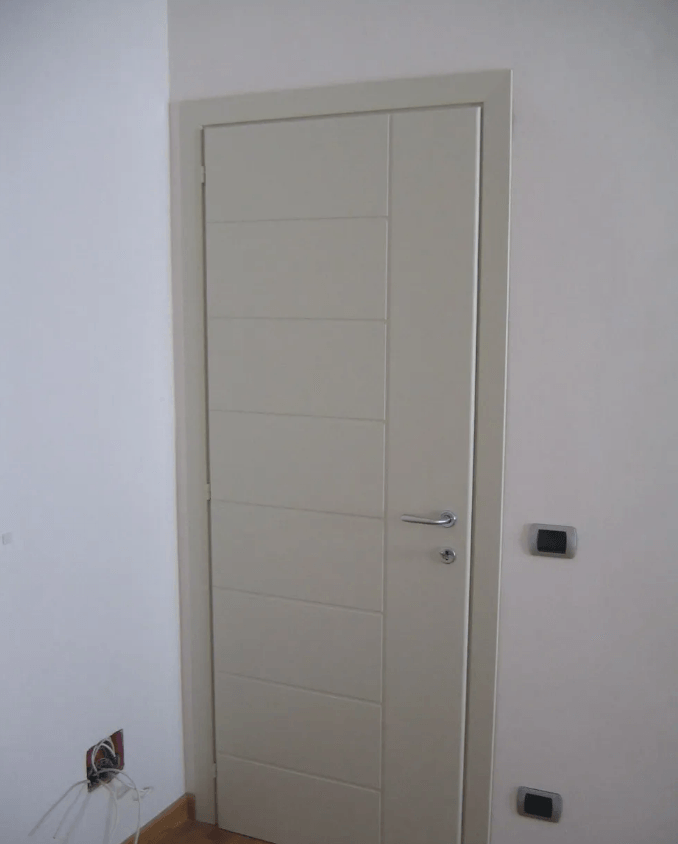 Porta interna beige con pannelli orizzontali, maniglia argentata e telaio di colore chiaro.