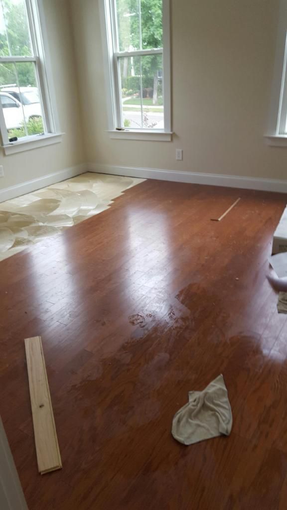 A room with hardwood floors and two window