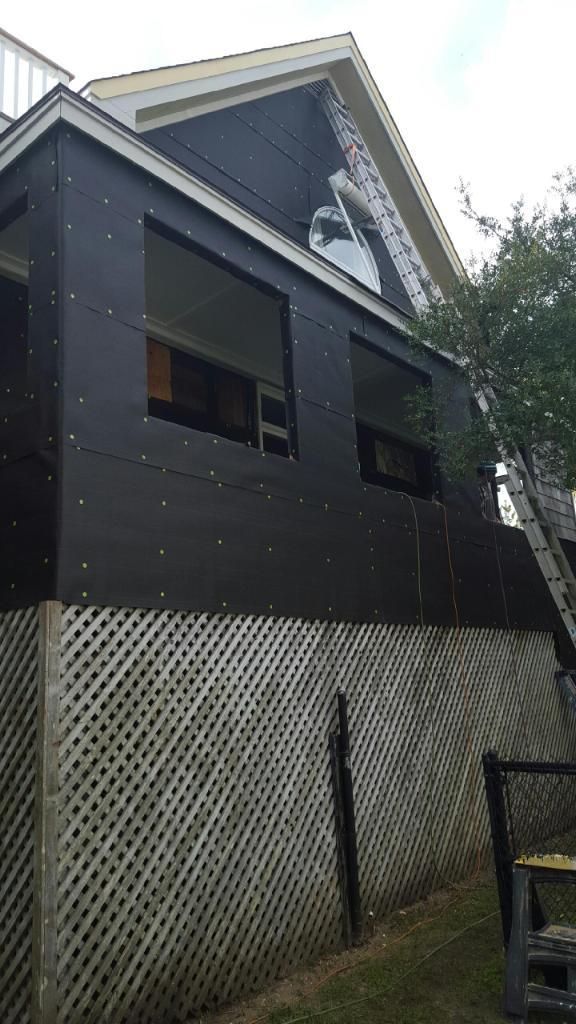 A house with a lattice fence around it is being remodeled.