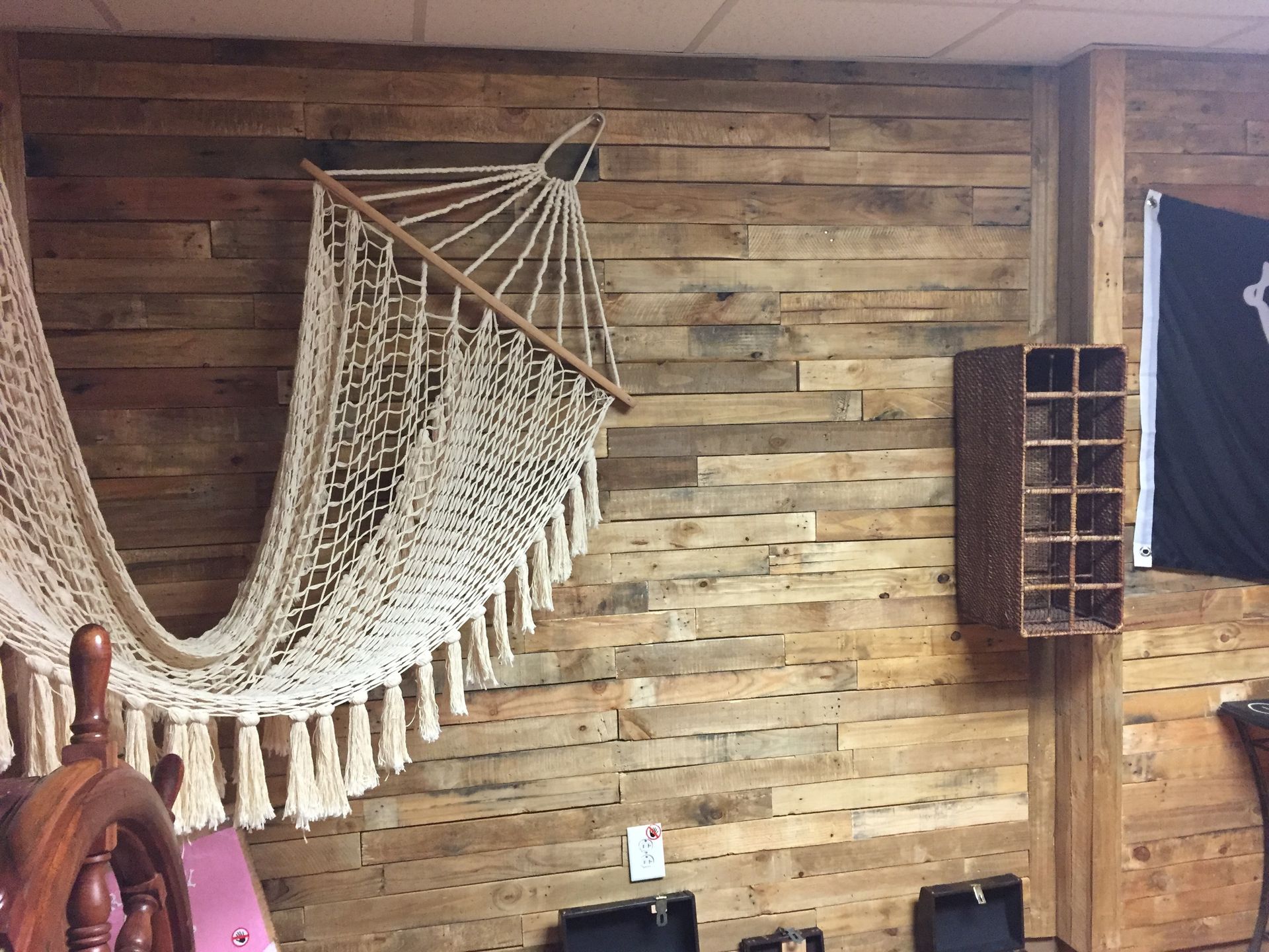 A hammock is hanging on a wooden wall in a room.