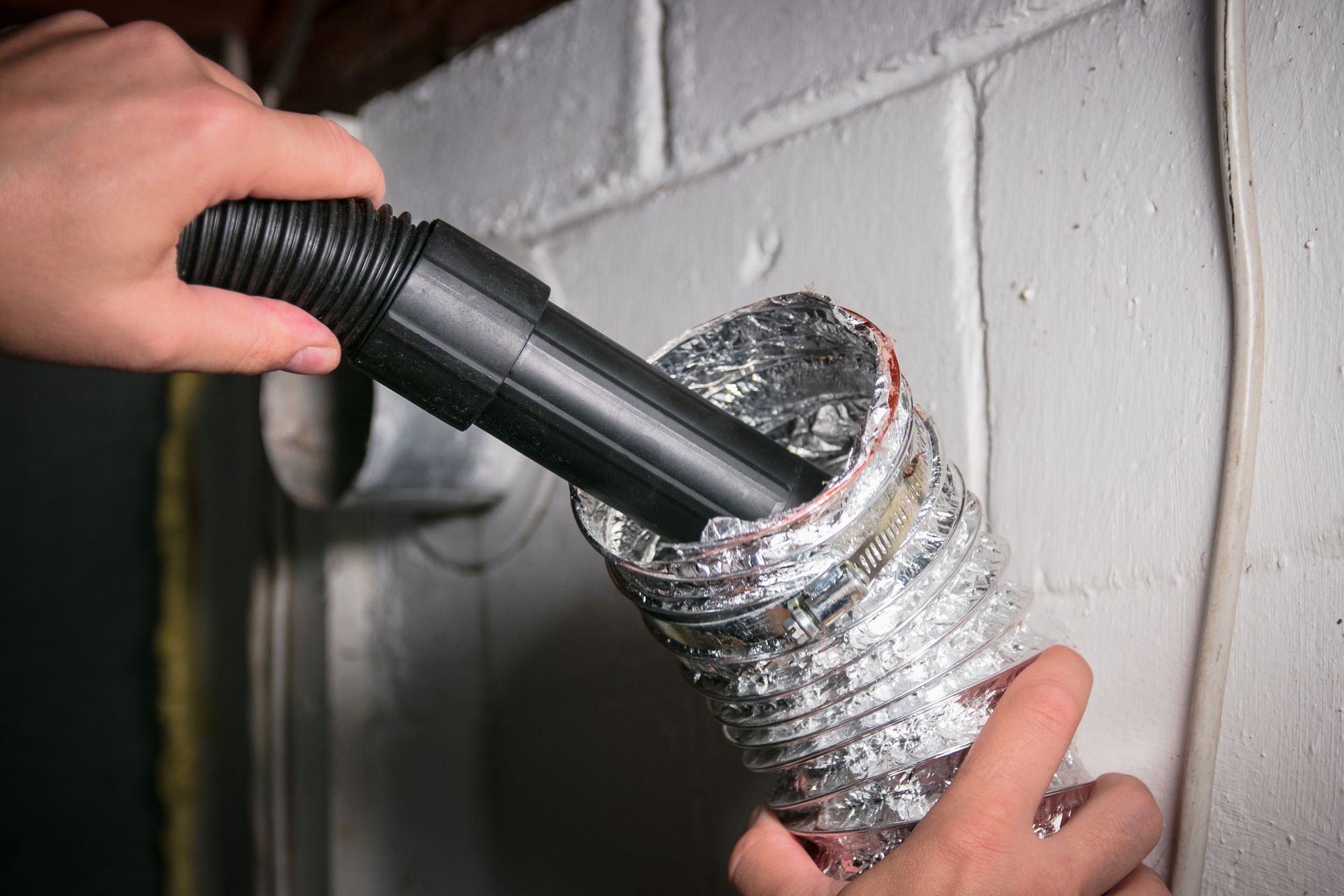 Close-up view of a dryer vent being cleaned.