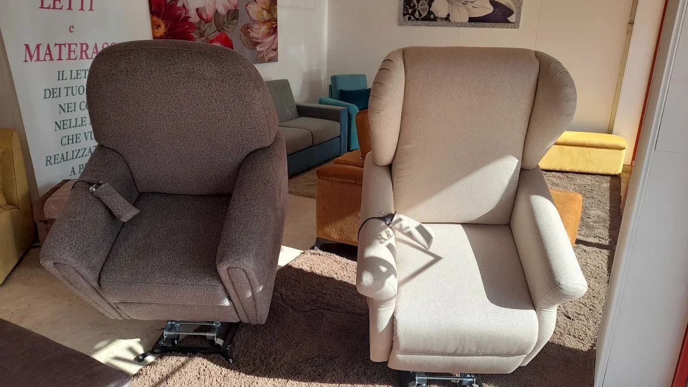 Due poltrone elevabili imbottite in uno showroom. Una marrone, una beige.