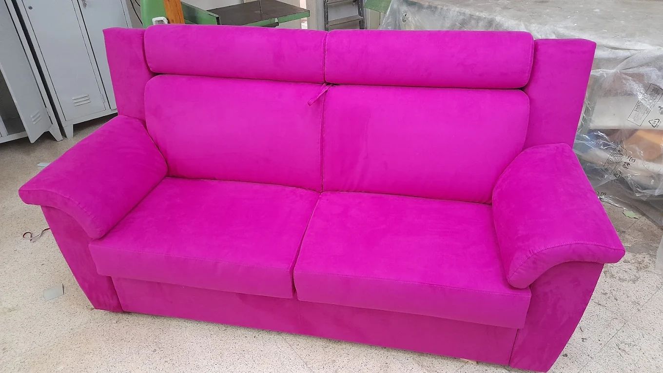 Divano a due posti rosa shocking con schienale, braccioli e seduta imbottiti.