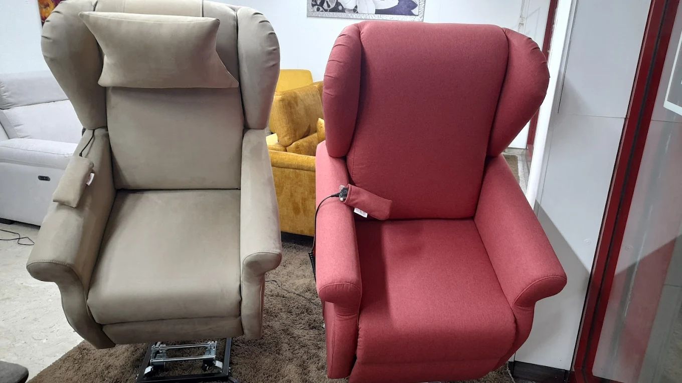Due poltrone reclinabili elevabili in uno showroom, una color cuoio e una rossa.