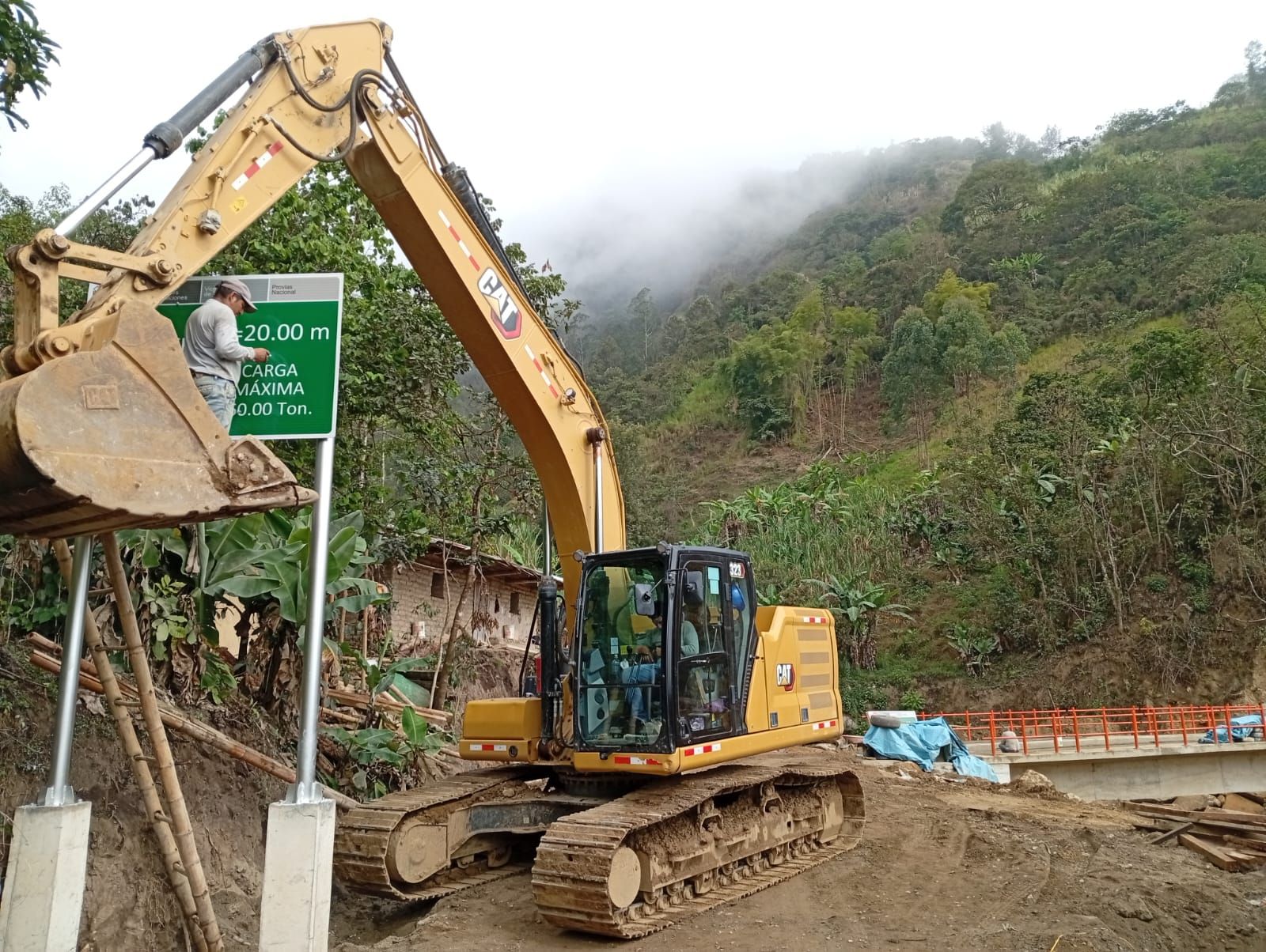 Excavadora amarilla en un lugar de trabajo al lado de una carretera