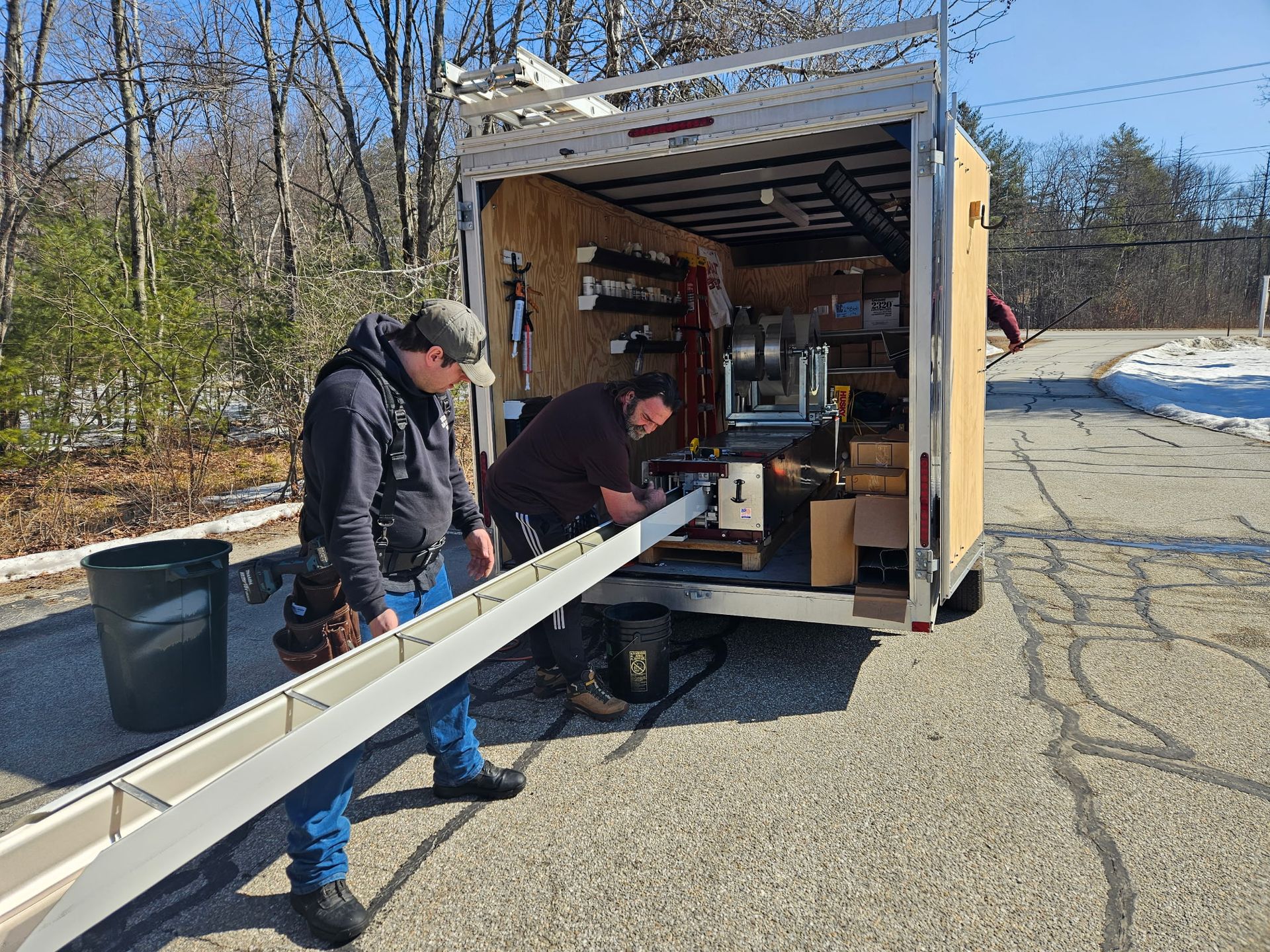 Co-Owners Daniel Foote and David Williamson making seamless gutters on our gutter machine.