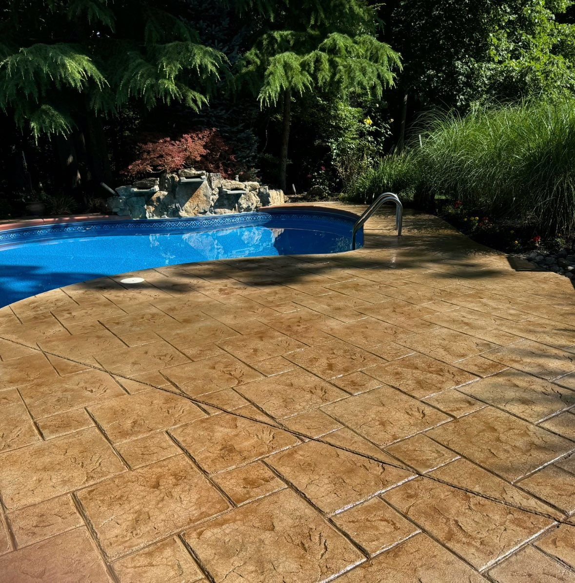 Two-story brick house with a tan garage door, green lawn, and blue sky.