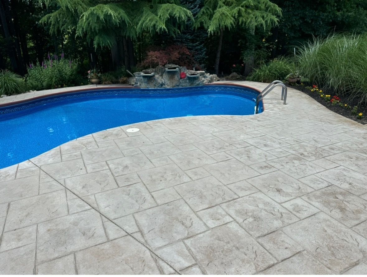 Brick walkway with scattered brown leaves, bordered by green grass.
