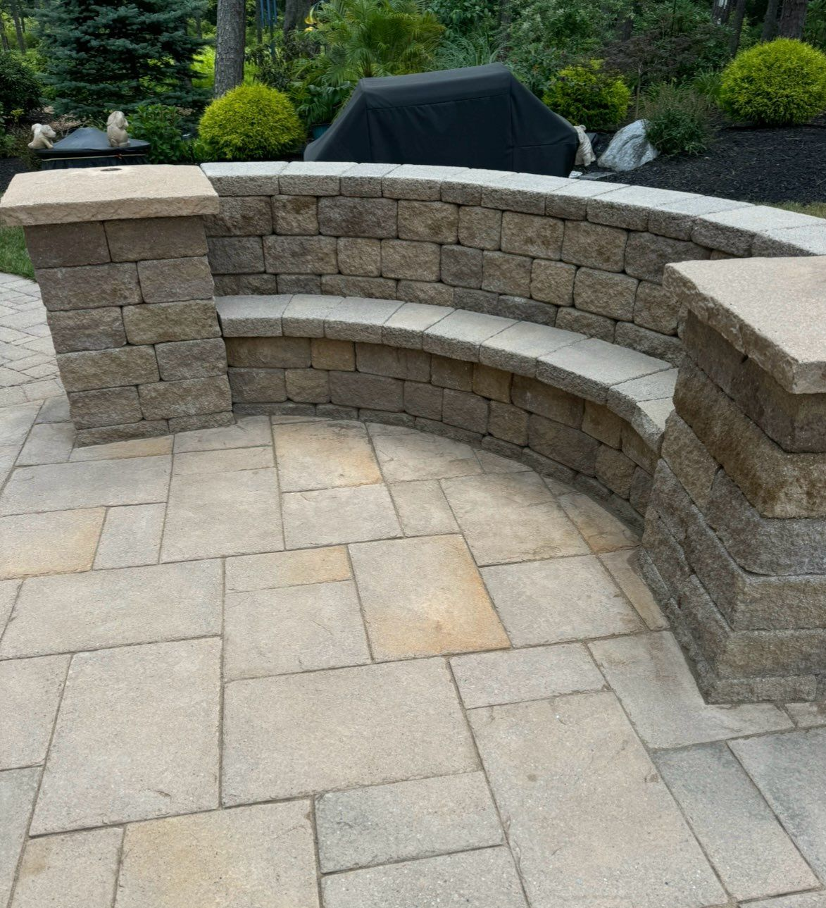 Brick walkway with scattered brown leaves, bordered by green grass.