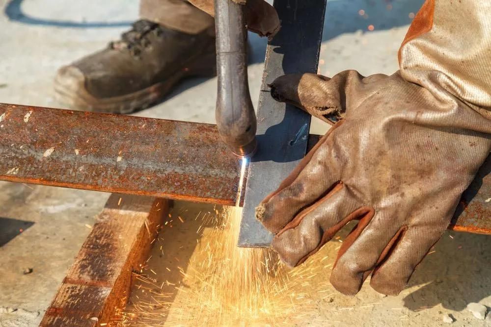 A Person Wearing Gloves Is Welding A Piece Of Metal — HardRok Engineering Pty Ltd In Mount Isa, QLD