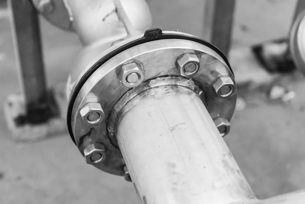 A Black And White Photo Of A Stainless Steel Pipe With A Flange — HardRok Engineering Pty Ltd In Mount Isa, QLD