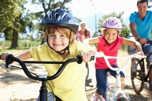 A group of children are riding bicycles in a park.