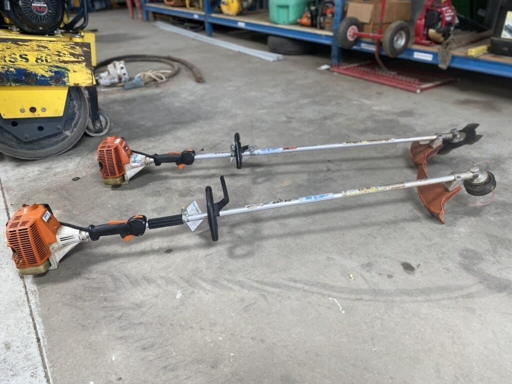 Two Stihl Trimmers Are Sitting on the Ground in a Warehouse — Hamblin Hire in Albury, NSW