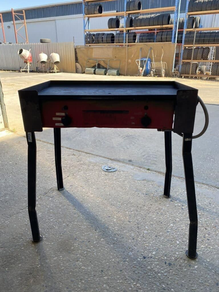 A Red and Black Table is Sitting on the Ground in a Parking Lot — Hamblin Hire in Albury, NSW
