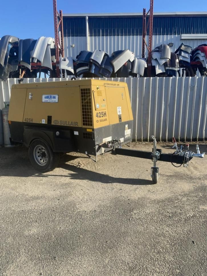 A Yellow Air Compressor is Parked on a Trailer in a Parking Lot — Hamblin Hire in Albury, NSW