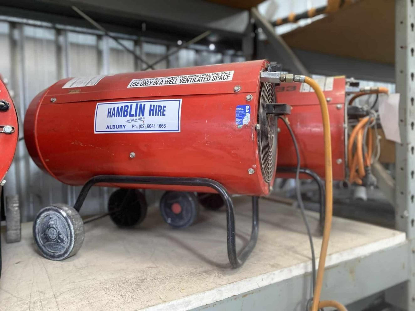 A Red Heater is Sitting on a Shelf in a Warehouse — Hamblin Hire in Albury, NSW