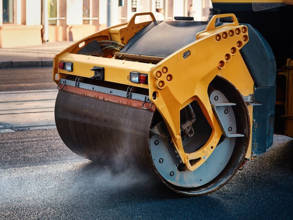 A Yellow Roller is Rolling Asphalt on a City Street — Hamblin Hire in Albury, NSW