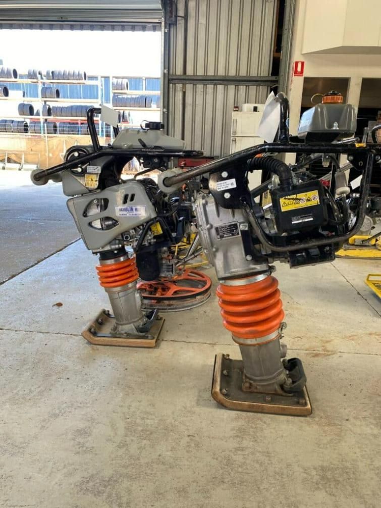 Two Vibratory Compactors Are Sitting on the Floor in a Garage — Hamblin Hire in Albury, NSW