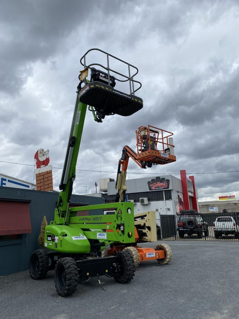 A Green Aerial Lift is Parked in Front of a Building — Hamblin Hire in Albury, NSW