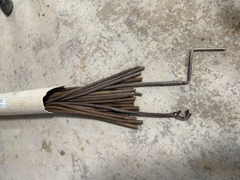 A Bunch of Metal Rods Are Sitting on the Ground Next to a Pipe — Hamblin Hire in Albury, NSW