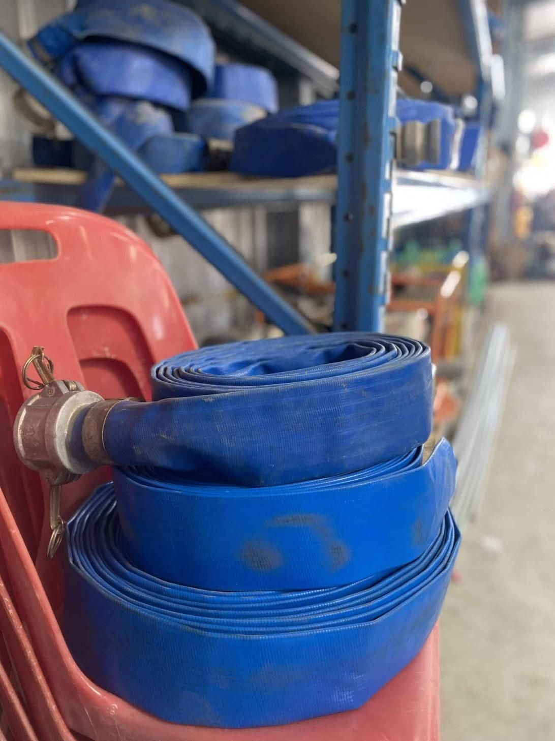 Two Blue Hoses Are Stacked on Top of Each Other in a Warehouse — Hamblin Hire in Albury, NSW