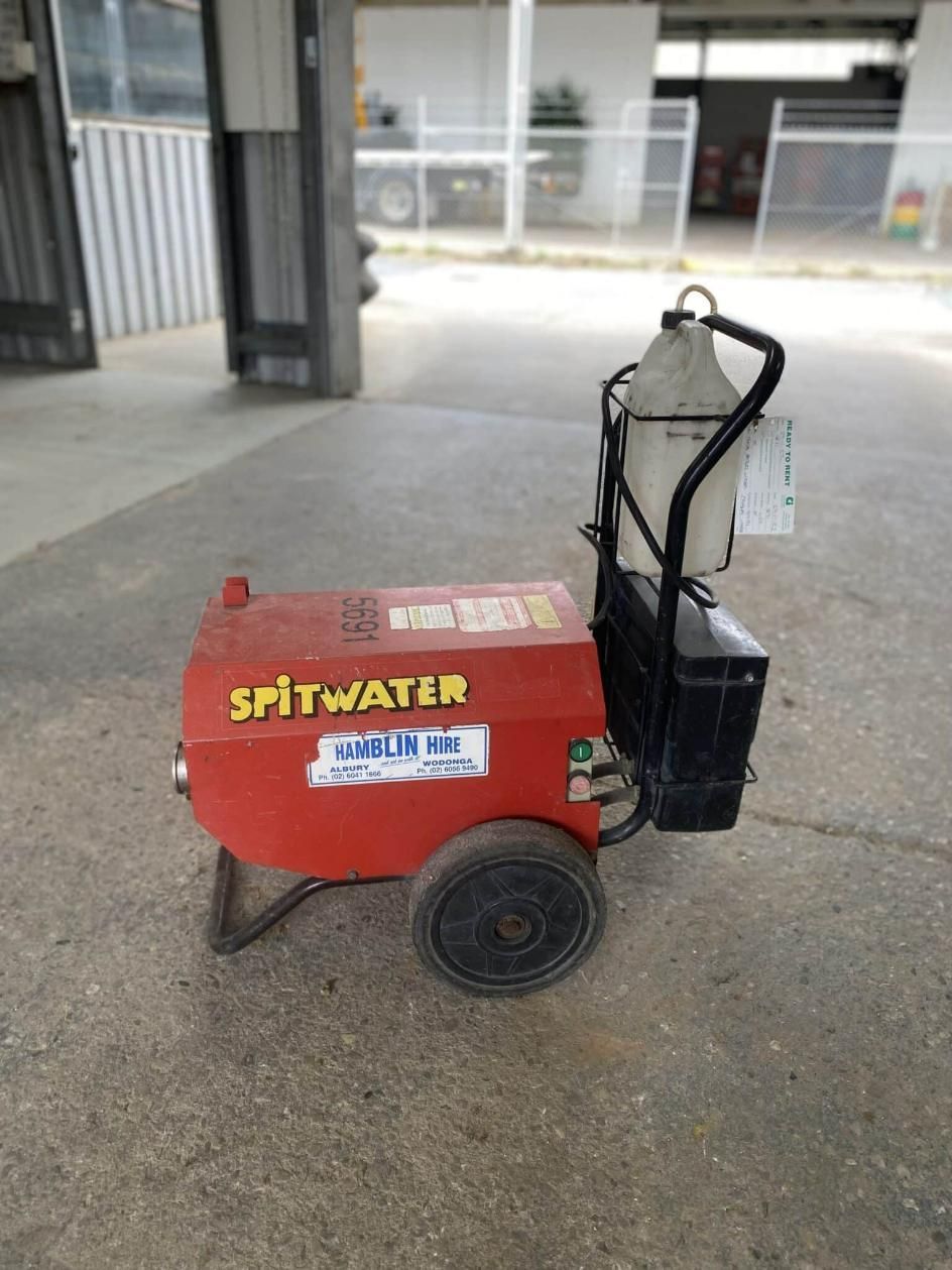 A Red Spitwater Machine is Sitting on the Ground in a Parking Lot — Hamblin Hire in Albury, NSW