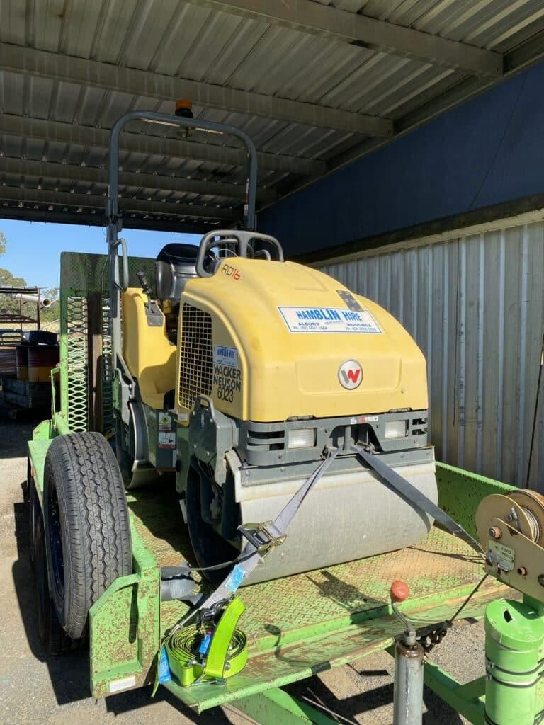 A Yellow Roller is Sitting on Top of a Green Trailer — Hamblin Hire in Albury, NSW