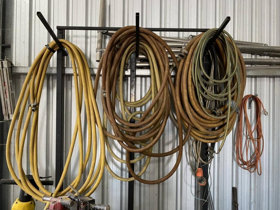 A Bunch of Hose Hanging on a Rack in a Garage — Hamblin Hire in Albury, NSW