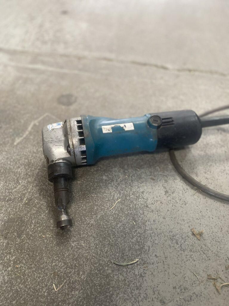 A Metal Cutting Machine is Sitting on a Concrete Floor — Hamblin Hire in Albury, NSW