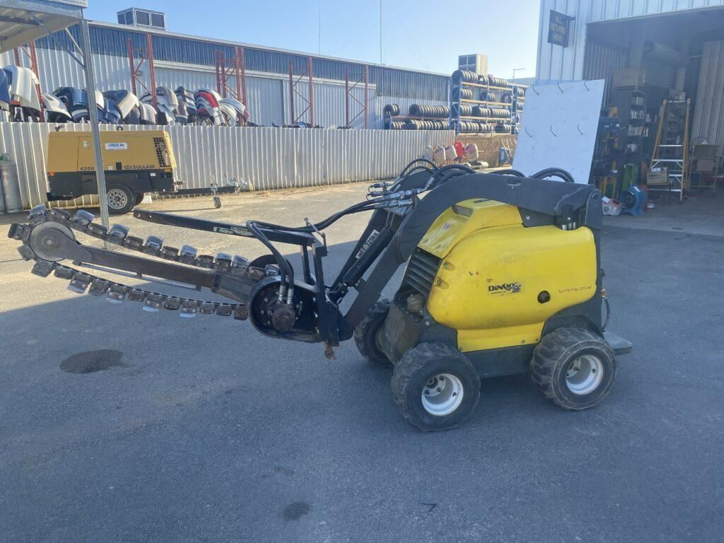 A Yellow Tractor With a Chainsaw Attached to It is Parked in a Parking Lot — Hamblin Hire in Albury, NSW