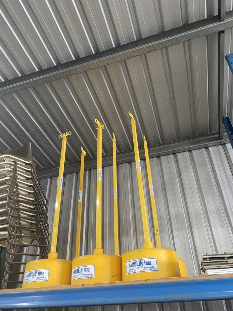 A Bunch of Yellow Poles Are Sitting on Top of a Shelf — Hamblin Hire in Albury, NSW