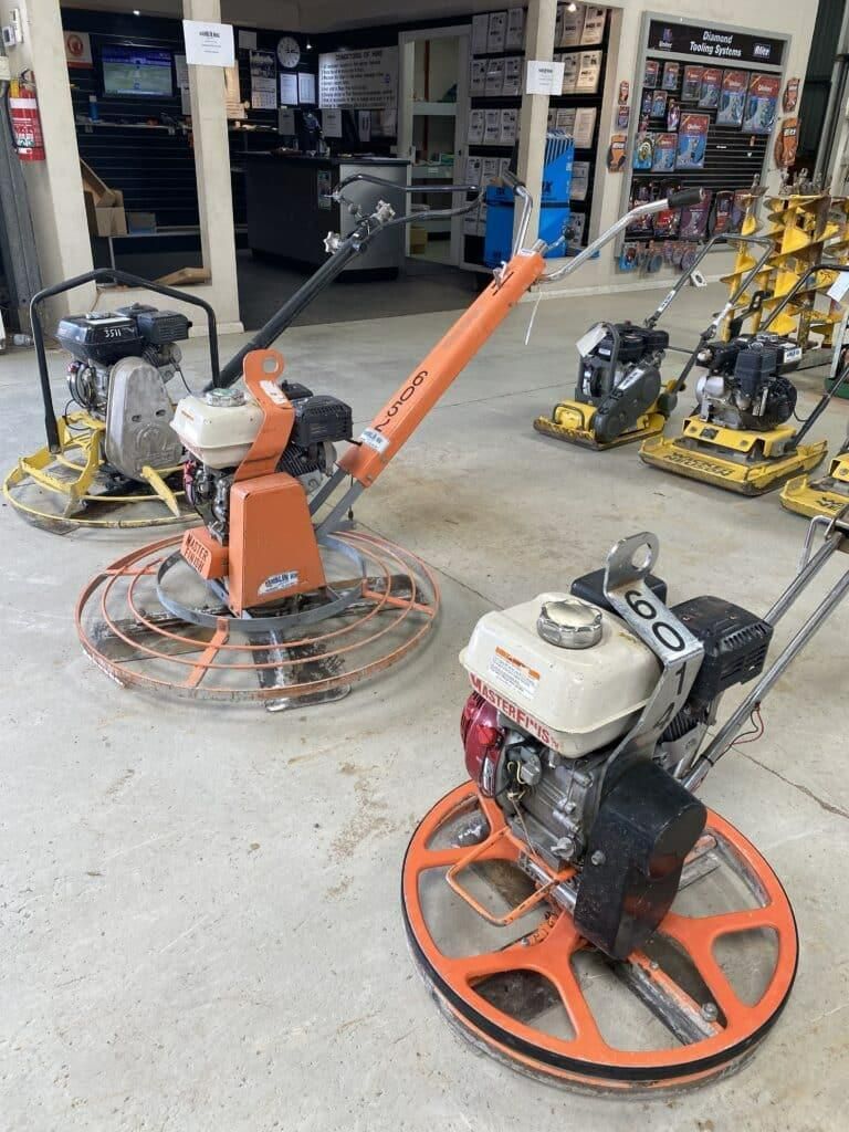A Couple of Concrete Trowel Machines Sitting on Top of a Concrete Floor — Hamblin Hire in Albury, NSW