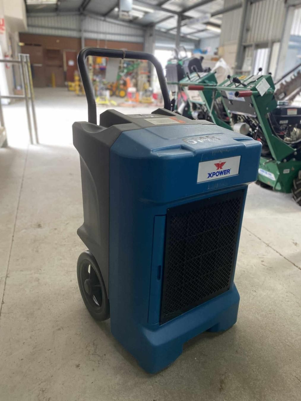 A Blue and Black Machine With Wheels is Sitting in a Warehouse — Hamblin Hire in Albury, NSW